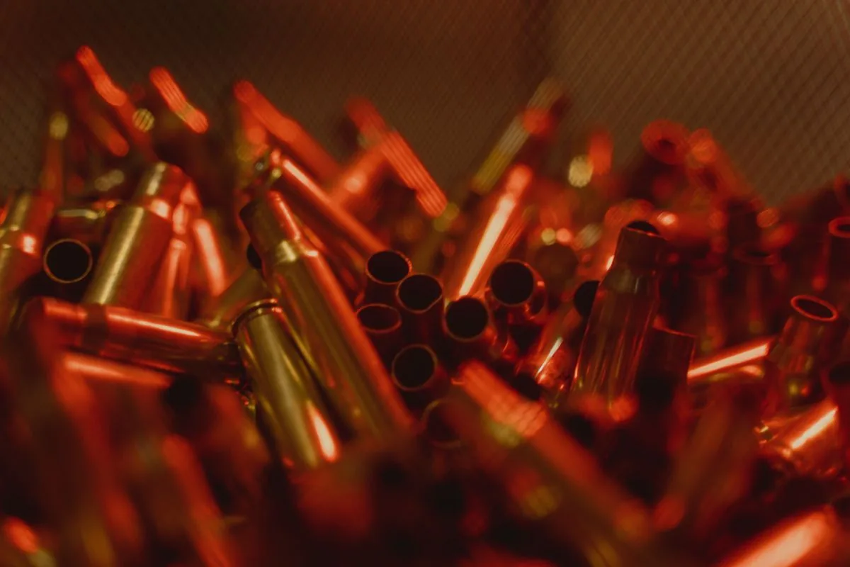 Full length vs neck sizing: fired rifle brass cases in a bin ready to resize