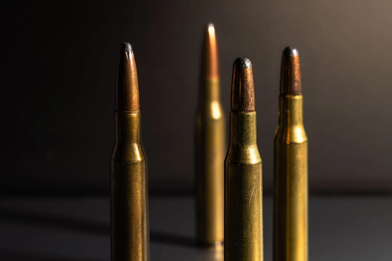 bullet runout: four loaded rifle cartridges standing upright